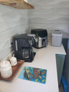 a kitchen counter with a coffee maker and a toaster at The Lost Loggerhead- OBX Ocean view Beach House in Avon