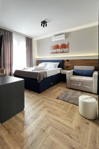 a bedroom with a bed and a couch at ĆAKA Luxury Rooms & Restaurant in Ćuprija