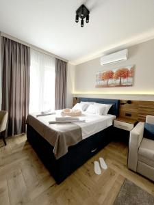 a bedroom with a large bed and a chair at ĆAKA Luxury Rooms & Restaurant in Ćuprija