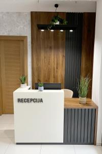 a reception desk in a lobby with plants on it at ĆAKA Luxury Rooms & Restaurant in Ćuprija