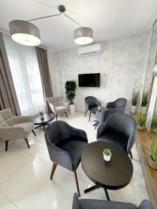 sala de estar con sillas, mesa y TV en ĆAKA Luxury Rooms & Restaurant en Ćuprija