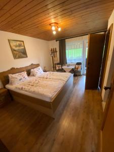 Schlafzimmer mit einem Bett und Holzboden in der Unterkunft Landhaus Aigner in Mittersill