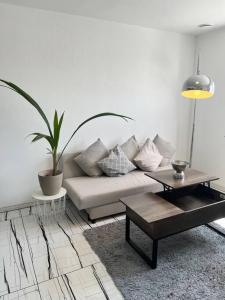 Sala de estar blanca con sofá y mesa en Feel like Home 1, en Biberach an der Riß