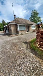 a house with a gravel driveway in front of it at Strathalban cottage in Aberlour