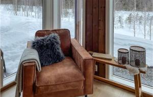 uma cadeira de couro castanha com uma almofada peluda ao lado de uma janela em 4 Bedroom Gorgeous Home In Hnefoss em Hønefoss