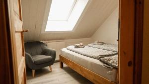 1 dormitorio con 1 cama, 1 silla y 1 ventana en Ferienwohnung Selent Familie Sikora, en Selent