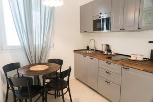 Arena Rooms في فيرونا: مطبخ مع طاولة صغيرة وكراسي في مطبخ