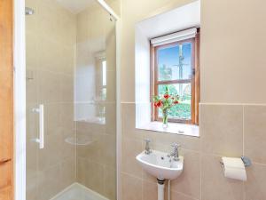 a bathroom with a sink and a shower and a window at The Cider House in Clee Saint Margaret