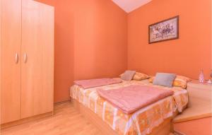 Bett in einem Zimmer mit orangefarbener Wand in der Unterkunft 2 Bedroom Nice Apartment In Turanj in Turanj