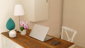 a desk with a laptop and a lamp on it at Casale Giuseppe in Fasano