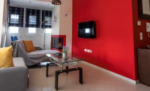 a living room with a red wall and a tv at Holiday Lefkas Moonlight Luxury Appartments in Nikiana