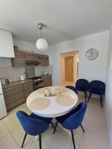 弗瓦迪斯瓦沃沃的住宿－Mieszkanie Balticana，厨房里配有一张白色的桌子和蓝色的椅子