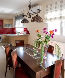 una cucina con tavolo in legno e fiori di Holiday Lefkas Moonlight Luxury Appartments a Nikiana