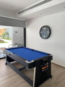a pool table in a room with a clock on the wall at Cactus Dead Sea Jordan in Al Rama