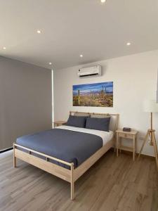 una camera da letto con un grande letto con una coperta blu di Cactus Dead Sea Jordan a Al Rama