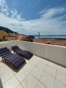 a group of lounge chairs on a roof at Sea Holiday Houses in Drasnice