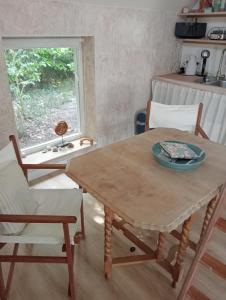 een tafel en stoelen in een keuken met een raam bij Tiny House Aqualinde in Breda