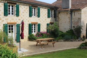 a house with a wooden bench in front of it at Domaine de la Basse Bobinière - Gîte et Chambres d'hôtes in Thouarsais-Bouildroux +13 photos