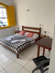- une chambre avec un lit, une table et une fenêtre dans l'établissement Pousada Fortaleza, à Parati