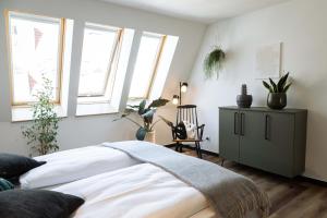 a bedroom with a bed and a cabinet and windows at Urban Jungle Apartments in Vienna