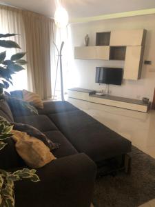 a living room with a couch and a flat screen tv at Stanza vicino Paceville e San Giuliano in Is-Swieqi