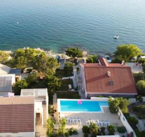 an aerial view of a house and a swimming pool at Beachfront Apartments Anita with Pool in Karlobag