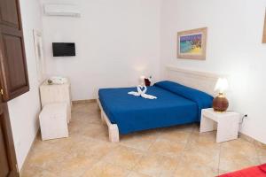 Un dormitorio con una cama azul con una flor blanca. en Agriturismo Villa Tommaso en Torre dell'Orso