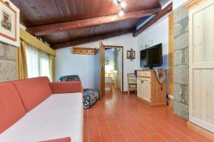 a living room with a couch and a television at 38-Casa Volpin Relax e Sport in Toscana in Castel del Piano