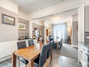 a kitchen and dining room with a wooden table and chairs at Braefield in Portpatrick