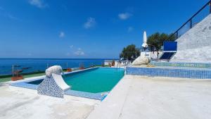 a swimming pool with the ocean in the background at La Dea del Mare in Forio d'Ischia