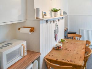 une petite cuisine avec une table en bois et un four micro-ondes dans l'établissement Anchors Away, à Margate