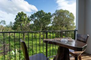 een tafel en stoelen op een balkon met uitzicht op een veld bij Krabi Lighthouse @ Aonang in Ao Nang Beach