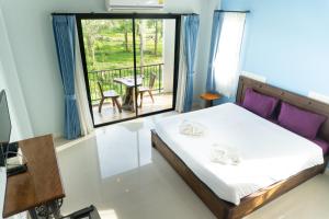 a bedroom with a bed and a balcony with a table at Krabi Lighthouse @ Aonang in Ao Nang Beach