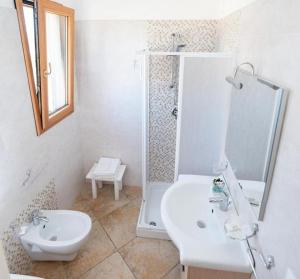 y baño con ducha, aseo y lavamanos. en Agriturismo Villa Tommaso en Torre dell'Orso