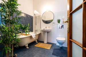 een badkamer met een bad, een wastafel en een toilet bij The- POINT- 3BR Bright Cloud in Boekarest