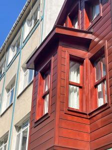 a wooden building with windows in front of a building at Mimoza Guesthouse in Istanbul