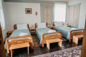 Habitación con 2 camas y 2 sillas en Guest House Edmond, en Gjirokastra