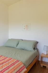 een slaapkamer met een bed en een nachtkastje met een lamp bij The Common Knowledge Centre in Kilfenora