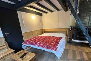 a bedroom with a bed with a red and white blanket at Charmant chalet Le Bouton D'or in Métabief