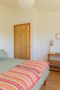 a bedroom with a bed and a wooden door at The Common Knowledge Centre in Kilfenora