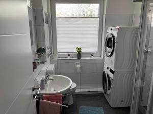 uma casa de banho com um lavatório e uma máquina de lavar roupa em Ferienwohnung Baustraße em Hameln