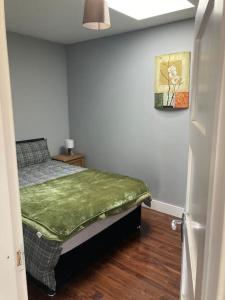 a bedroom with a bed with a green blanket on it at Copper rose guest house 