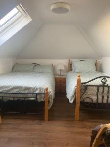 a attic bedroom with two beds and a window at Copper rose guest house 