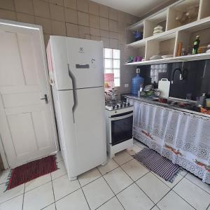 uma cozinha com um frigorífico branco e um fogão em Casa de Campina em Campina Grande