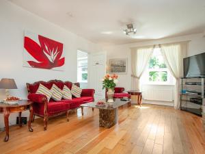 a living room with a red couch and a tv at Teign Retreat in Teignmouth