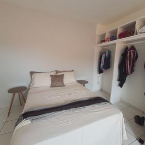 ein weißes Bett in einem Zimmer mit einem Schrank in der Unterkunft Casa de Campina in Campina Grande
