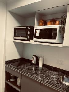 eine Küche mit zwei Mikrowellen und einer Arbeitsplatte in der Unterkunft ALQUILER TEMPORARIO VALENTINA in Resistencia