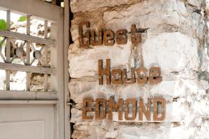 una señal en el lateral de un edificio con una puerta en Guest House Edmond, en Gjirokastra