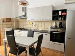 a kitchen with white cabinets and a table with chairs at Casa Riotorto in Riotorto