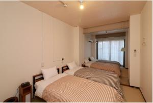 two beds in a room with a window at WAKURIAN,iwatacho - Vacation STAY 98982v in Okayama
